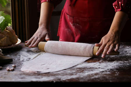 female hands with dough make homemade pasta