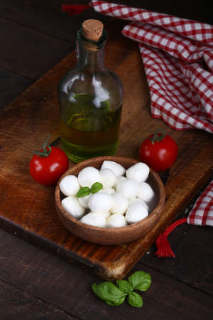 mini mozzarella cheese in a wooden bowl for saladの写真素材