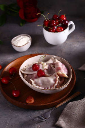 dumplings with cherries on a wooden tableの写真素材