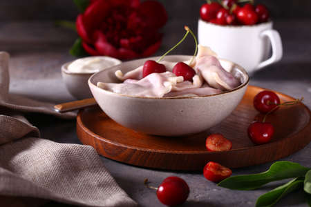 dumplings with cherries on a wooden tableの写真素材