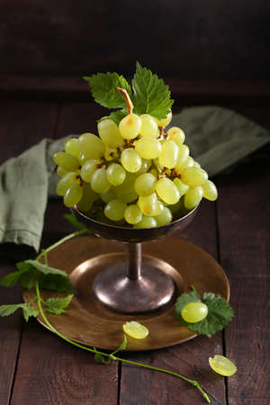 ripe organic grapes in a vase on the tableの写真素材