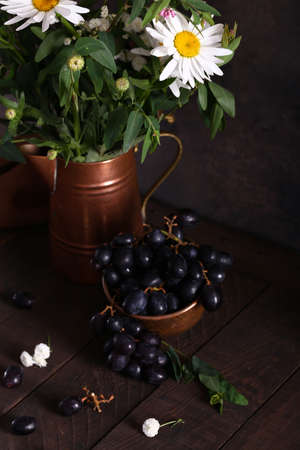 black organic grapes and flowers still lifeの写真素材
