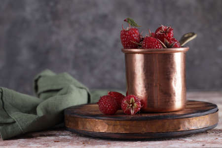 natural organic ripe raspberries in a copper mug