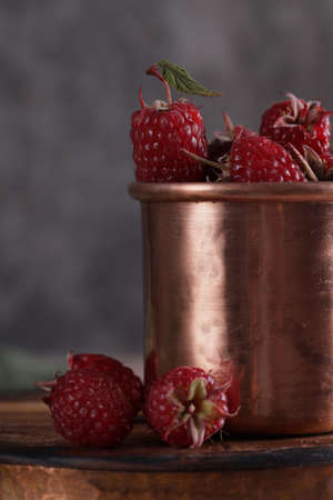 natural organic ripe raspberries in a copper mugの写真素材