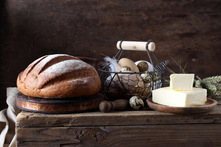 rustic still life with bread and butter on a wooden background
