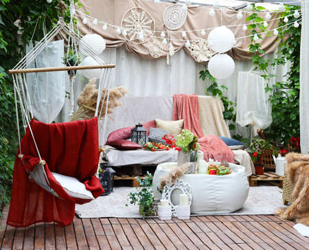 gazebo interior in folk style with pillows and coffee