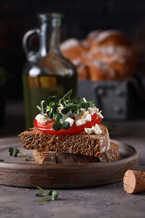 rye bread sandwich with tomatoes and herbsの写真素材