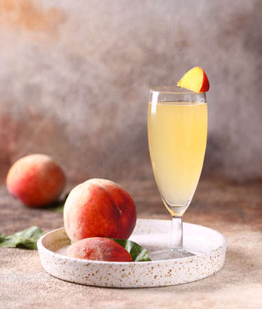 peach bellini cocktail with fresh fruitの写真素材