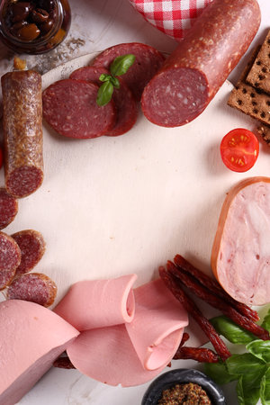 assortment of sausages and ham on wooden background, antipasti, appetizerの写真素材
