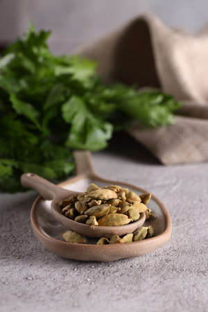organic spice cardamom in a ceramic spoon