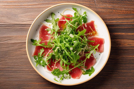 Beef carpaccio cold appetizer with parmesan, capers and arugula on white plateの素材