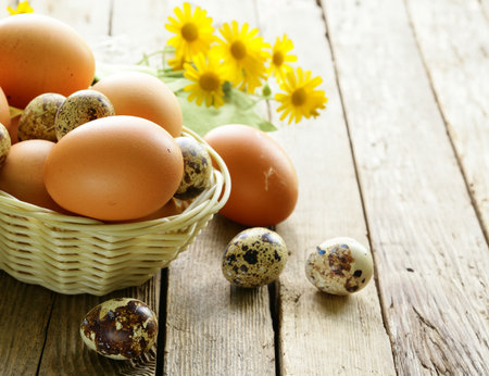 organic chicken and quail eggs in a basketの写真素材