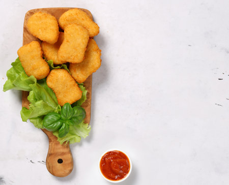 fried chicken nuggets on a wooden boardの写真素材
