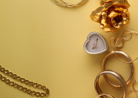 gold jewelry bracelet chain ring on a yellow backgroundの写真素材