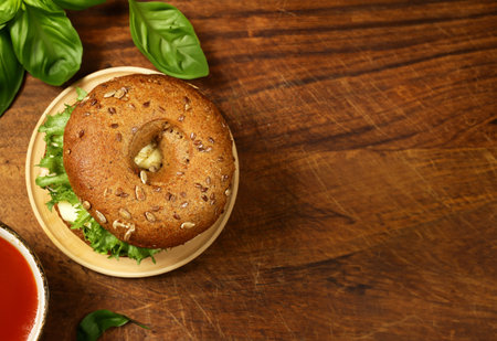 bagel with salad and cheese on a wooden boardの写真素材