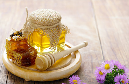 natural organic honey in honeycombs on a wooden tableの写真素材