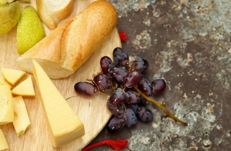 cheese board with baguette and grapesの写真素材