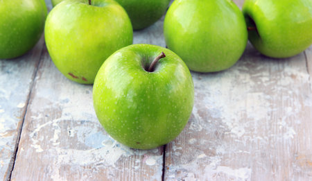 organic granny smith apples on wooden tableの写真素材