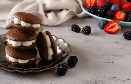 whoopie pie cookies with buttercream and berriesの写真素材