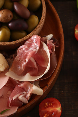 antipasti tapas with cheese and ham on wooden tableの写真素材