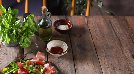 wooden food background table with basil and olive oilの写真素材