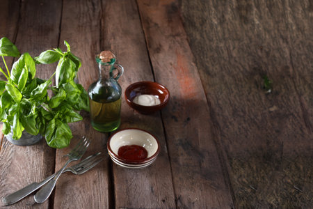 wooden food background table with basil and olive oilの写真素材