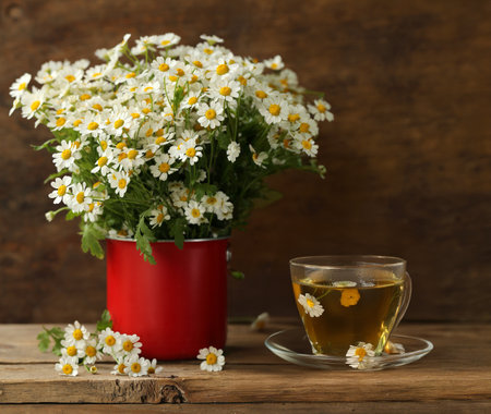 cup of herbal tea and a bouquet of chamomile flowersの写真素材