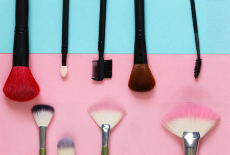 makeup brushes and eye shadow on a colored backgroundの写真素材