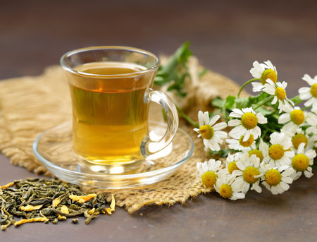 herbal chamomile tea in a cup on the tableの写真素材