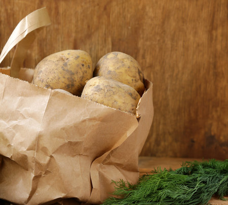 raw organic potatoes on wooden tableの写真素材