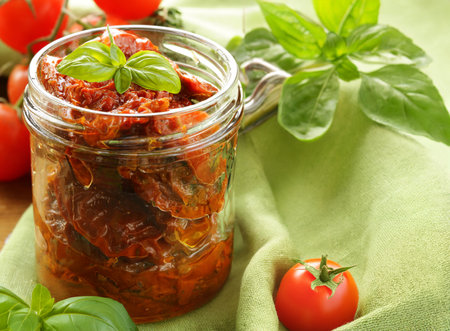 traditional Italian sun-dried tomatoes in oil with basilの写真素材