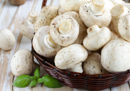 organic mushrooms champignons on a rustic wooden tableの写真素材