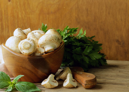 organic mushrooms champignons on a rustic wooden tableの写真素材