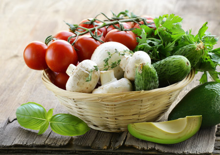 organic fresh vegetables in a basket on the tableの写真素材