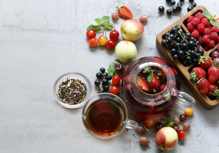 fruit tea in a teapot with fresh berriesの写真素材