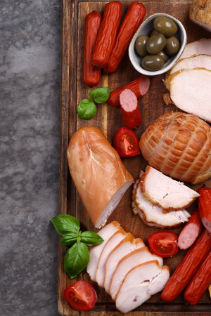 deli meats sausage on a wooden board for appetizerの写真素材