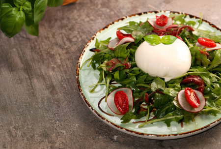 salad with burrata cheese on a plateの写真素材