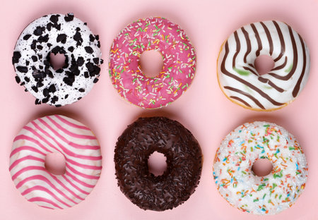 donuts with colored glaze on a pink backgroundの写真素材