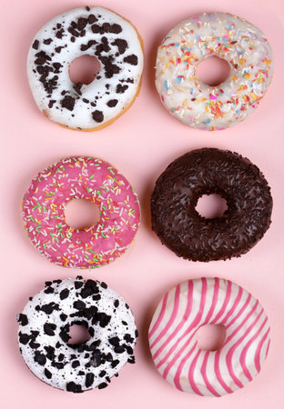 donuts with colored glaze on a pink backgroundの写真素材
