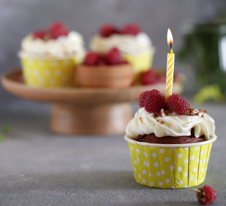 cupcakes with cream and holiday candlesの写真素材