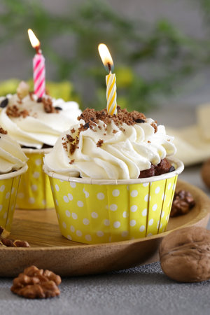 cupcakes with cream and holiday candlesの写真素材