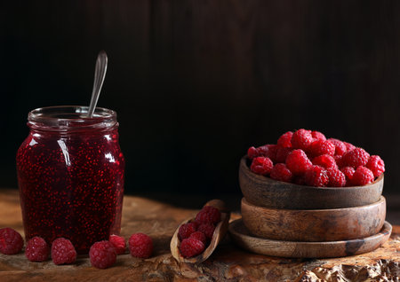 raspberry jam and fresh berries on wooden background