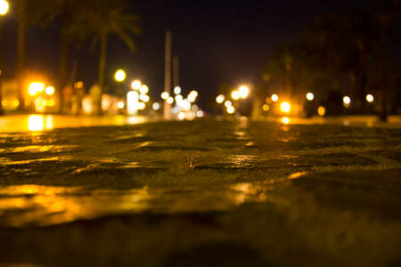 Dark street from the ground in cobblestones different colors lantern square blue spanish city cartagena europe european blurry lights light beamの写真素材