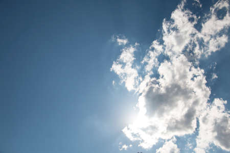 Blue sky with white clouds and the sun