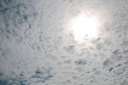 Blue sky with thin clouds covering the sun on the sunny dayの写真素材