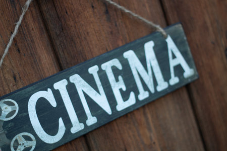 Cinema Sign Displayed on a Rustic Wooden Background, Evoking Vintage Charm and Nostalgiaの写真素材