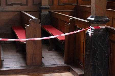 Church pews with barrier tape for social distancing-religious context