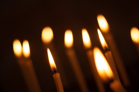Many lit candles with glowing flames creating a warm atmosphereの写真素材
