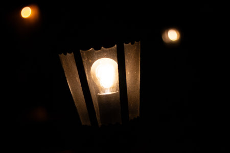Warm glowing light bulb framed by dark vertical lines