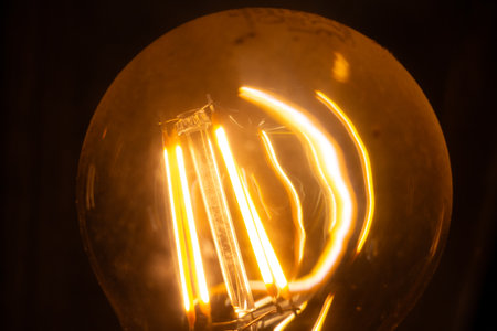 Close-up of a glowing Edison light bulb with a warm filament
